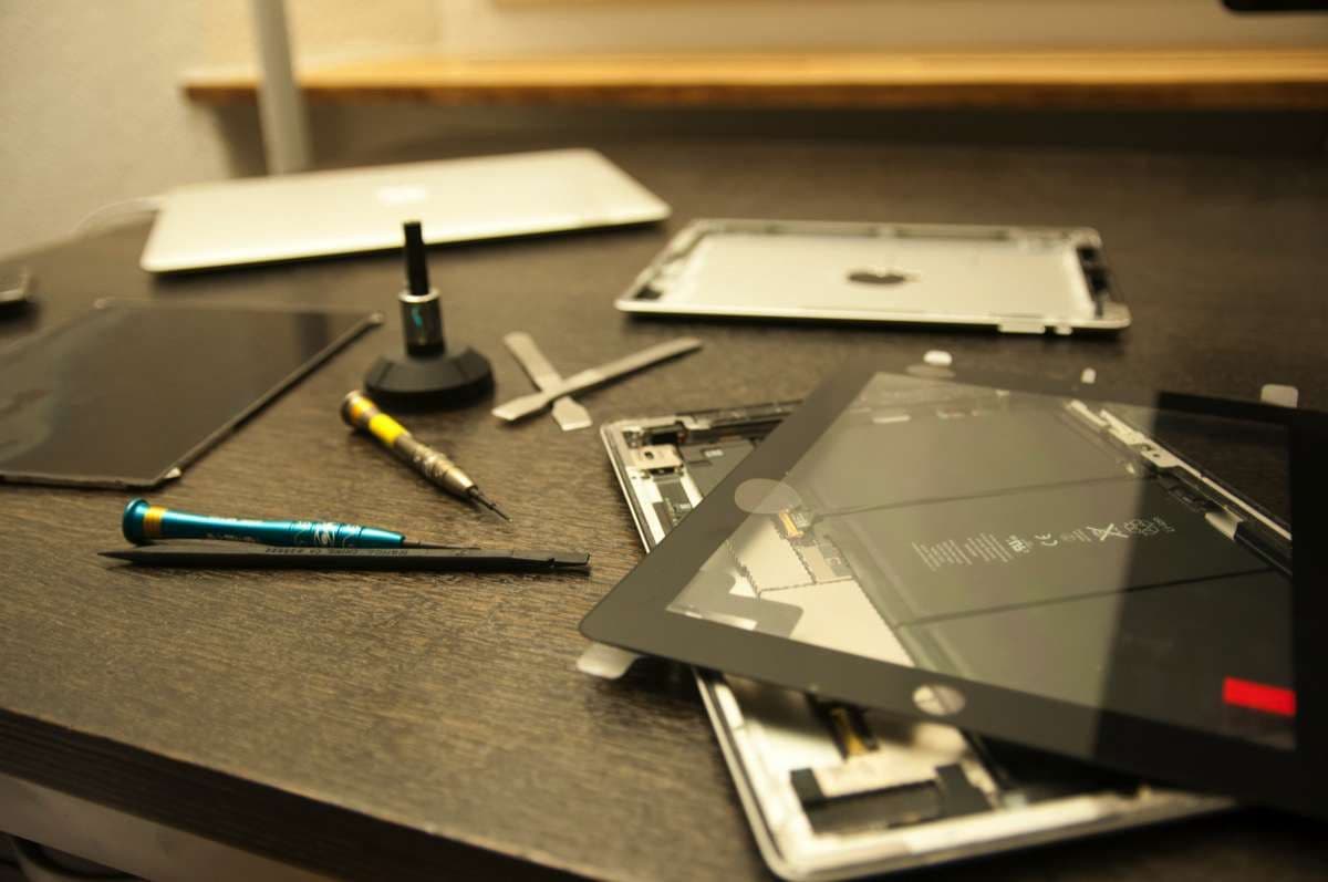 Reparaturplatz mit geöffnetem Tablet und Werkzeug