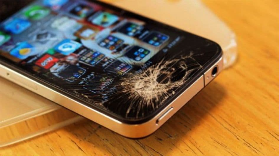 iPhone mit gebrochenem Display auf einem Holztisch